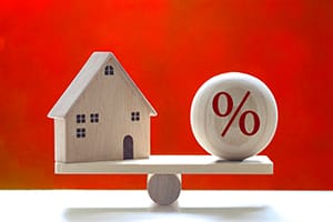 House balancing next to a percent sign, rate change 